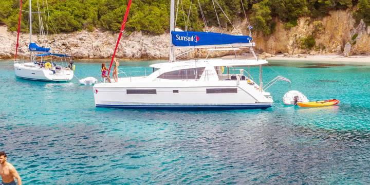Catamaran Anchoring and People Stand Up Paddling Corfu Island