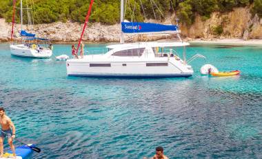 Catamaran Anchoring and People Stand Up Paddling Corfu Island