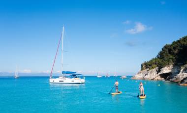 Monohull and paddleboarders in Corfu